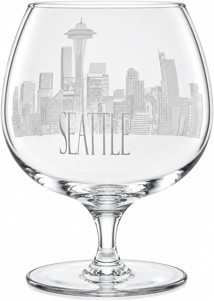 Clear glass snifter wine glass featuring an etched grayscale Seattle skyline and the word 'SEATTLE' on the bowl, shown on a white background.