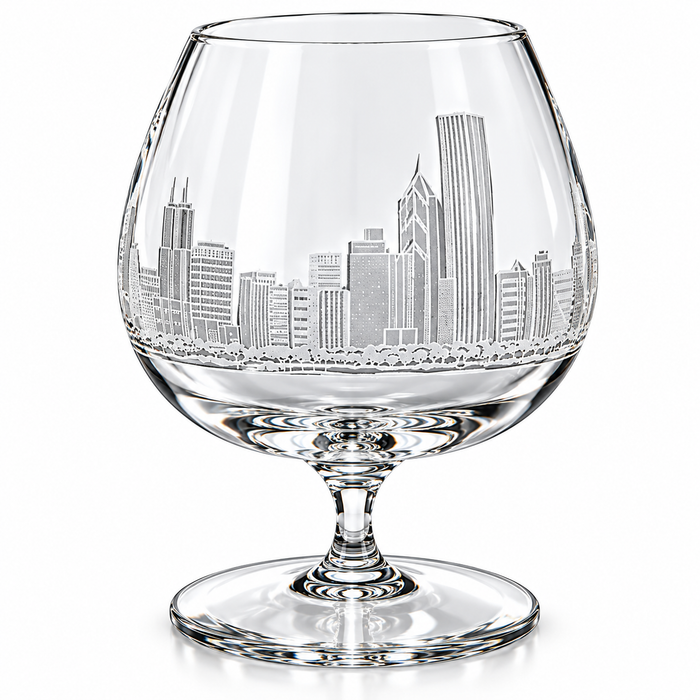 Clear crystal cognac glass with an etched Philadelphia skyline design on the bowl, set against a plain white background.