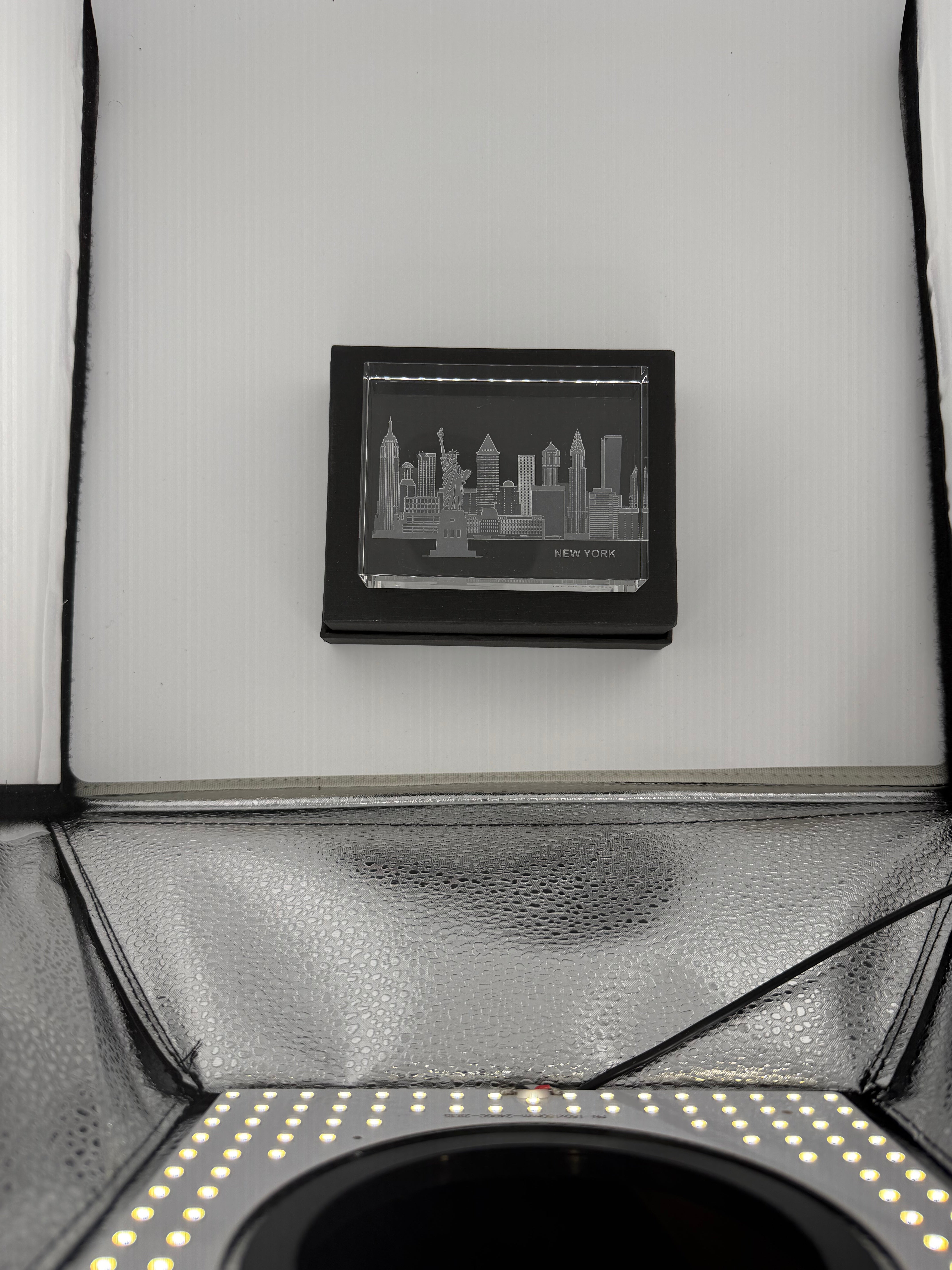 Sand-carved crystal paperweight featuring intricate city skyline engraving by Crystal House artisans.”