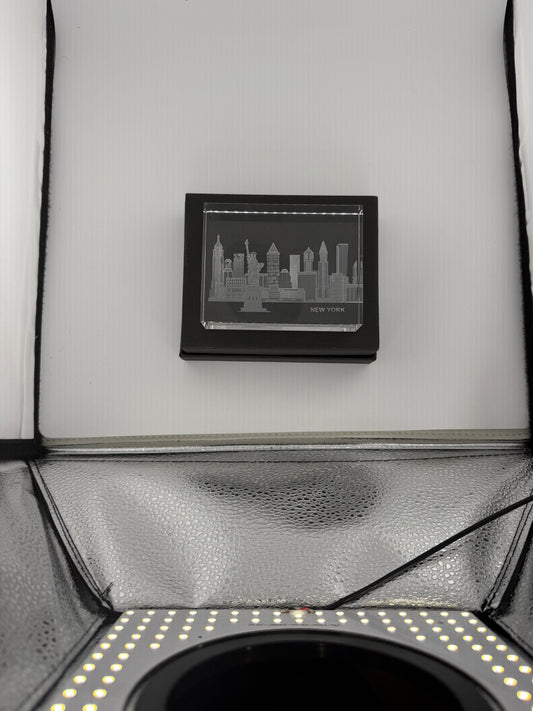 Sand-carved crystal paperweight featuring intricate city skyline engraving by Crystal House artisans.”