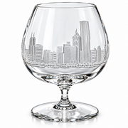 Clear crystal cognac glass with an etched Philadelphia skyline design on the bowl, set against a plain white background.
