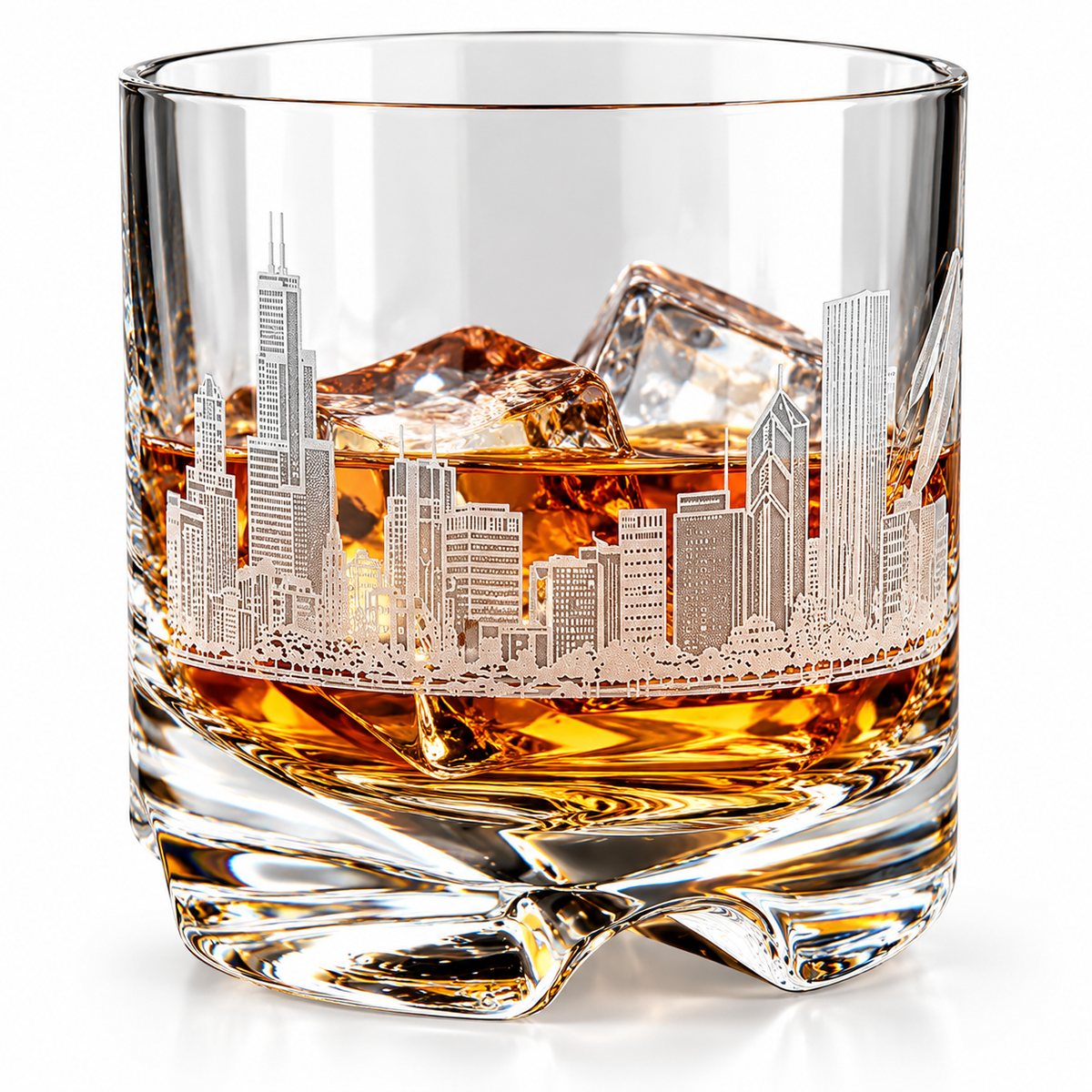 A clear glass whiskey tumbler with an etched Chicago skyline design, filled with amber liquor and ice cubes, shown on a white background.