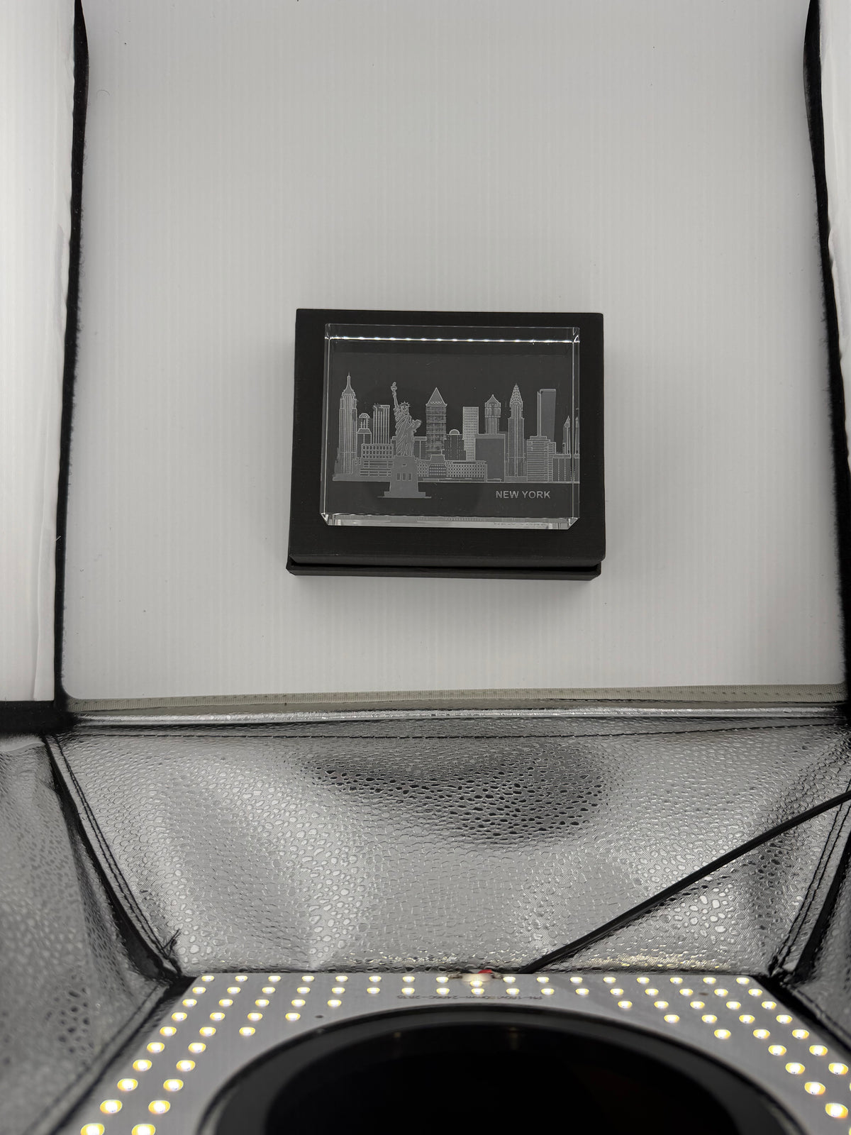 Sand-carved crystal paperweight featuring intricate city skyline engraving by Crystal House artisans.”