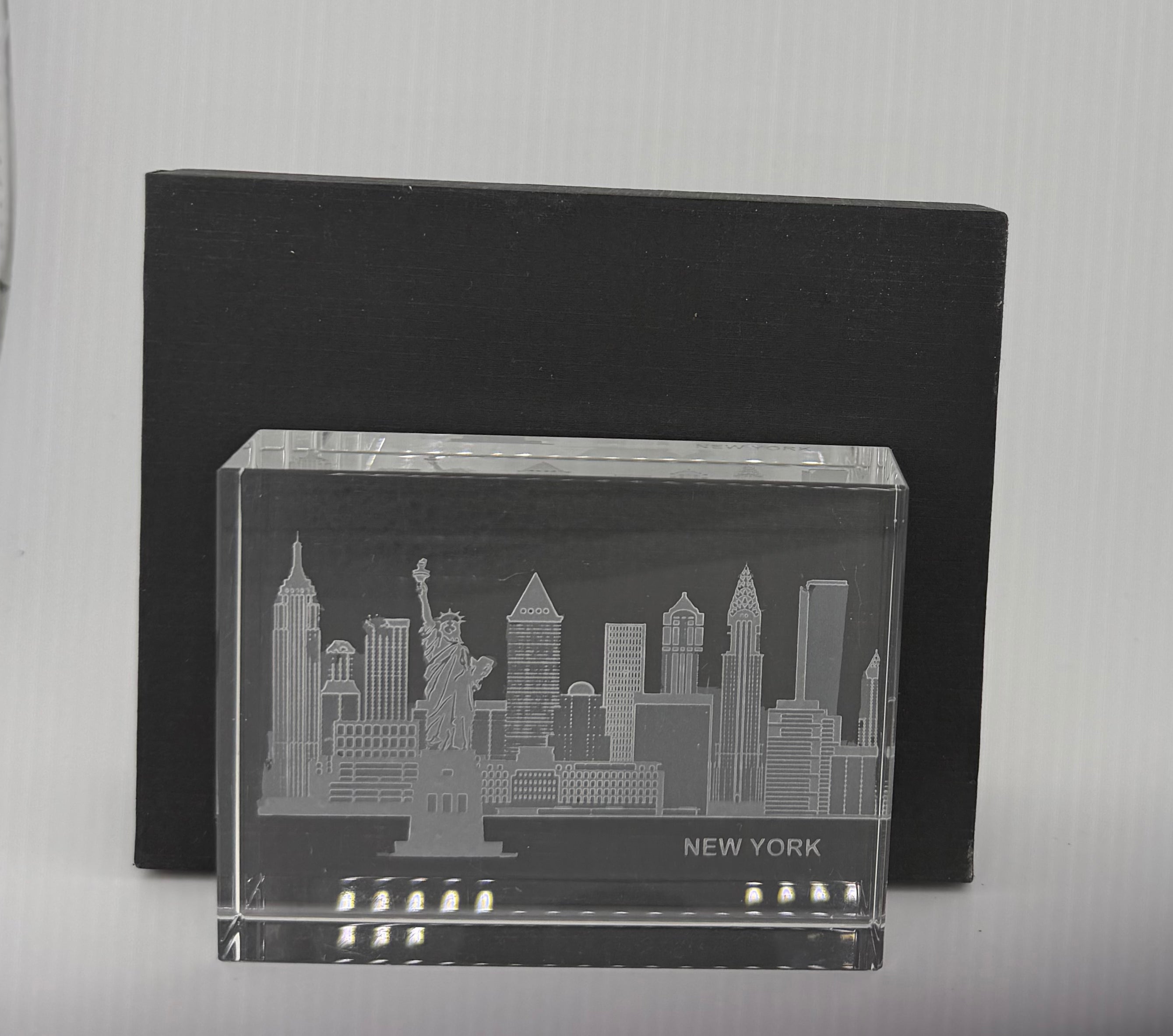Sand-carved crystal paperweight featuring intricate city skyline engraving by Crystal House artisans.